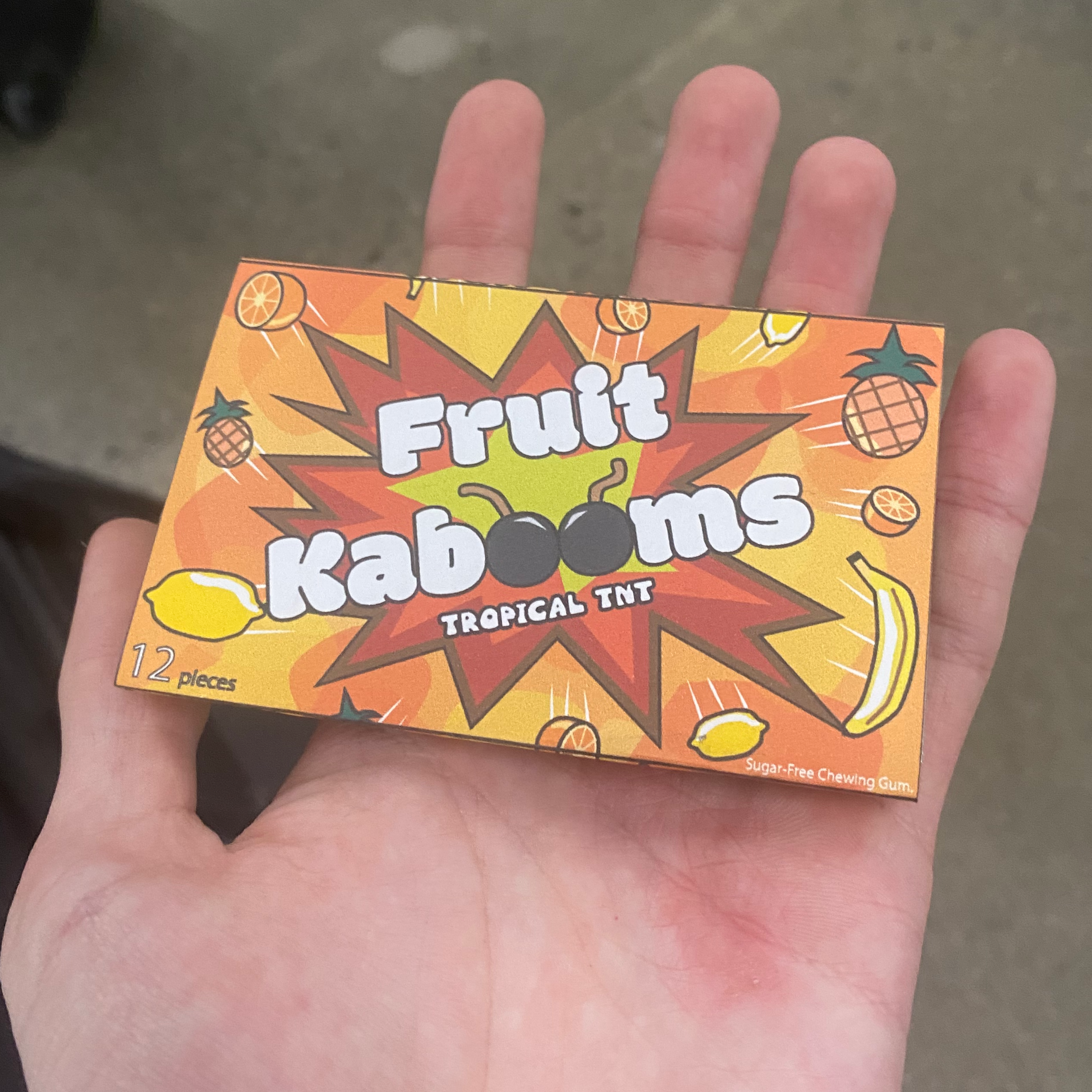 A mockup of a gum package being held in a hand.